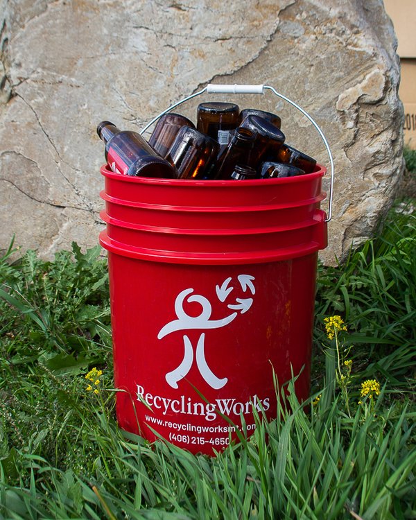 Recycling Works red 5 gallon bucket filled with bottles for their curbside glass recycling service in Missoula, Montana.